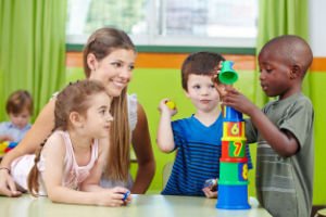 Preschool Students & Teacher building blocks